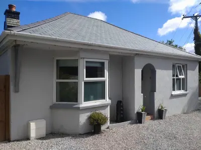 a white house with a window on a gravel driveway at Chy An Lur in Redruth