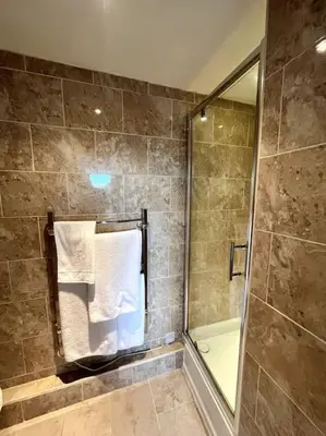 a bathroom with a shower and a towel at Riverside Apartment in Uny Lelant