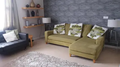 a living room with a couch and a chair at Riverside Apartment in Uny Lelant