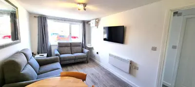 a living room with a couch and a chair at 8 Penhale in Perranporth