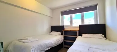 two beds in a room with a window at 8 Penhale in Perranporth