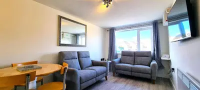 a living room with two chairs and a table at 8 Penhale in Perranporth