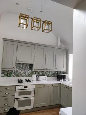 a kitchen with white cabinets and white counter tops at Tree Fern Barn in St Austell