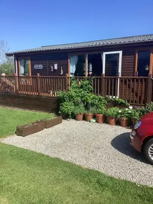 a house with potted plants in front of it at LakeView Lodge Trevella Park in Crantock