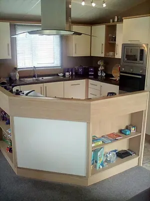 a kitchen with a counter in the middle of it at LakeView Lodge Trevella Park in Crantock