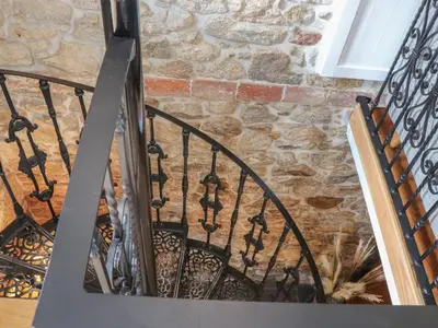 a spiral staircase with a stone wall at The Hayloft in Helston