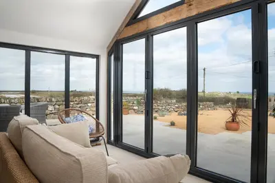 a living room with sliding glass doors at The Rum House in Helston
