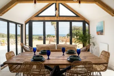 a dining room with a wooden table and chairs at The Rum House in Helston