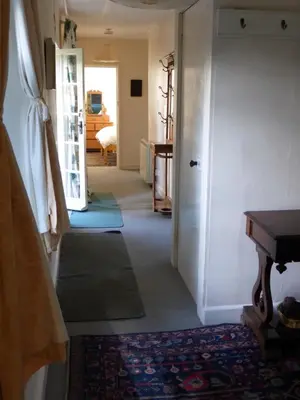 a hallway with a room with a door and a table at The Old Stables of heritage Tregrehan Garden Cottages on South Coast in St Austell