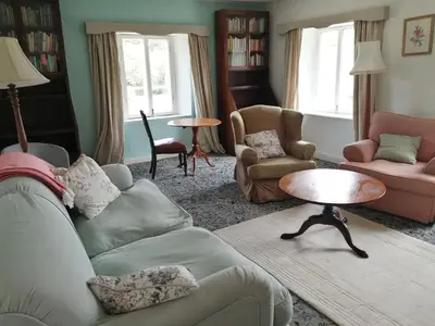 a living room with a couch and chairs and a table at The Old Stables of heritage Tregrehan Garden Cottages on South Coast in St Austell