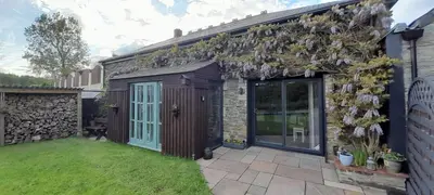 a garden with a building with plants on it at Wisteria Barn, Trewethen, Nr Port Isaac in Port Isaac