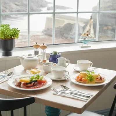 a wooden table with plates of food on it at Lugger Hotel ‘A Bespoke Hotel’ in Portloe