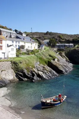 a small boat in the water on the beach at Lugger Hotel ‘A Bespoke Hotel’ in Portloe
