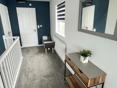 a room with a stairway with a table and a chair at Godrevy Lighthouse View, St Ives, free parking near beach in Carbis Bay