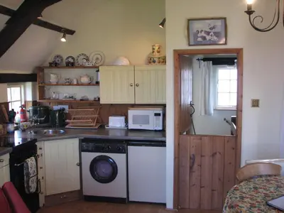 a kitchen with a dishwasher and a microwave in it at Church Cottage in Bude