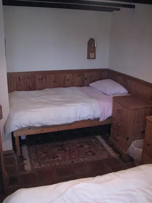 a bedroom with two twin beds and a dresser at Church Cottage in Bude