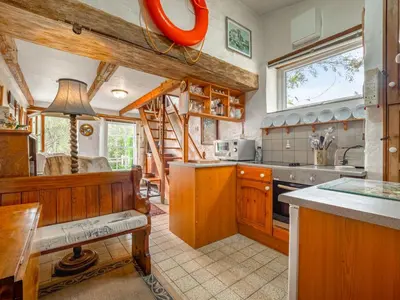 a large kitchen with wooden cabinets and a stove at Holiday Home The Homestead by Interhome in Gorran Haven
