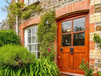a brick house with a wooden door at Holiday Home The Homestead by Interhome in Gorran Haven