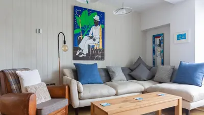a living room with a couch and a table at Castle House - Penthouse in Polruan