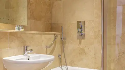 a bathroom with a sink and a shower at Castle House - Penthouse in Polruan
