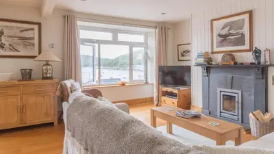 a living room with a couch and a fireplace at Castle House - Polruan in Polruan