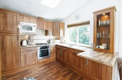 a kitchen with wooden cabinets and a stove top oven at 10 Trehawks in Wadebridge