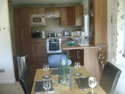 a kitchen with a table with wine glasses on it at 10 Trehawks in Wadebridge