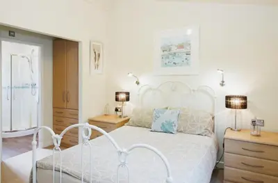 a bedroom with a white bed and two night stands at 10 Trehawks in Wadebridge