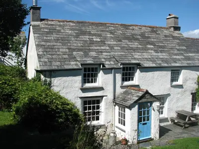 a white cottage with a slate roof at The Old Farmhouse in Crackington Haven