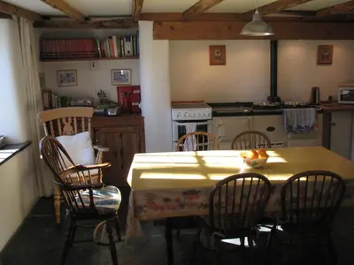 a kitchen with a table and chairs and a kitchen with a stove at The Old Farmhouse in Crackington Haven