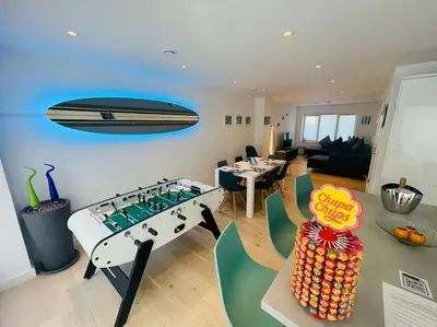 a living room with a table and a boat on the wall at 3 Bedroom Holiday Home by beach in Newquay in Newquay