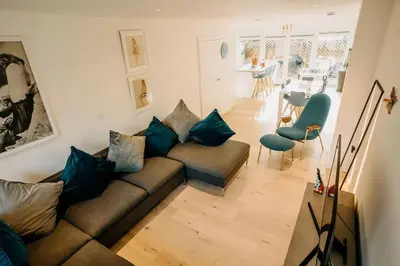 a living room with a couch and a dining room at 3 Bedroom Holiday Home by beach in Newquay in Newquay
