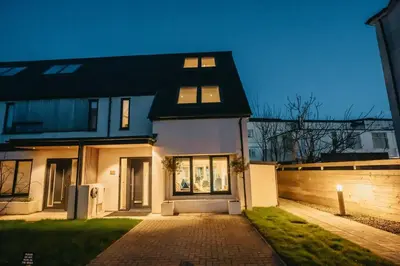 a white house with a black roof and a driveway at 3 Bedroom Holiday Home by beach in Newquay in Newquay