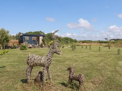a statue of a giraffe and a baby giraffe in a field at Dot May in Wadebridge