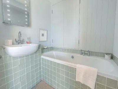 a bathroom with a bath tub and a sink at Dolphins Reach in Saint Mawes