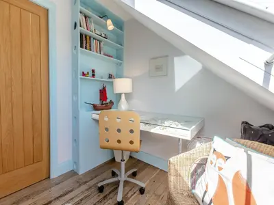 a room with a desk and a chair in a attic at Dolphins Reach in Saint Mawes