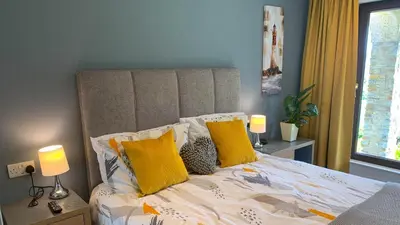 a bedroom with a bed with yellow pillows at Portmellon Cove Guest House in Mevagissey