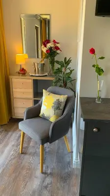 a chair with a pillow in a living room at Portmellon Cove Guest House in Mevagissey
