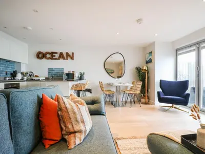 a living room with a couch and a table at Apartment 3 Fistral Beach in Newquay