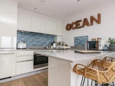 a kitchen with white cabinets and a counter top at Apartment 3 Fistral Beach in Newquay