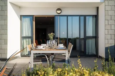 a white table and chairs on the balcony of a house at Barepta Cove, Stunning Carbis bay apartment in Carbis Bay