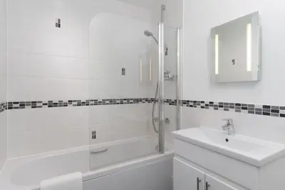 a white bathroom with a sink and a shower at Barepta Cove, Stunning Carbis bay apartment in Carbis Bay
