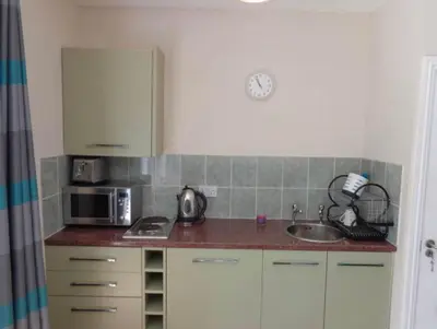 a kitchen with a sink and a microwave at Wadebridge Whitecross studio 1 in Wadebridge