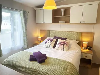 a bedroom with a large bed with purple towels on it at Pottsville Cabin Sleeps 4 with Deck in Praa Sands