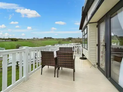 two chairs on a porch with a view of the golf course at Pottsville Cabin Sleeps 4 with Deck in Praa Sands