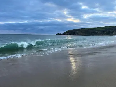 a beach with a small wave in the ocean at Pottsville Cabin Sleeps 4 with Deck in Praa Sands