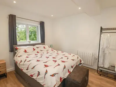 a bedroom with a bed with a comforter with birds on it at Pheasant View in Truro