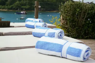 a group of towels sitting on a table near the water at BBCFeatured LuxuryInteriorDesignedWaterfront Home. in Saint Mawes