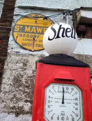 a clock on top of a red box with a sign at BBCFeatured LuxuryInteriorDesignedWaterfront Home. in Saint Mawes