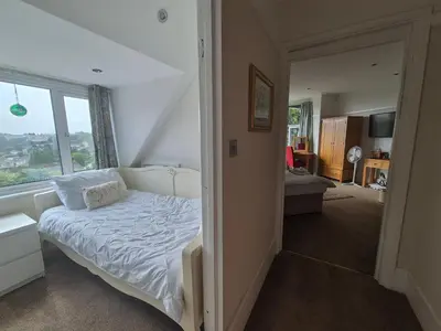 a bedroom with a white bed and a window at Tregarth House in St Austell